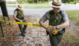 United States Park Rangers Josh Clemons, left, and Peter Zahrt close a trail at Mammoth Cave National Park, Ky. Tuesday, Oct., 1, 2013. National Parks across the country are closed due to the federal government shutdown. (AP Photo/The Daily News, Alex Slitz)