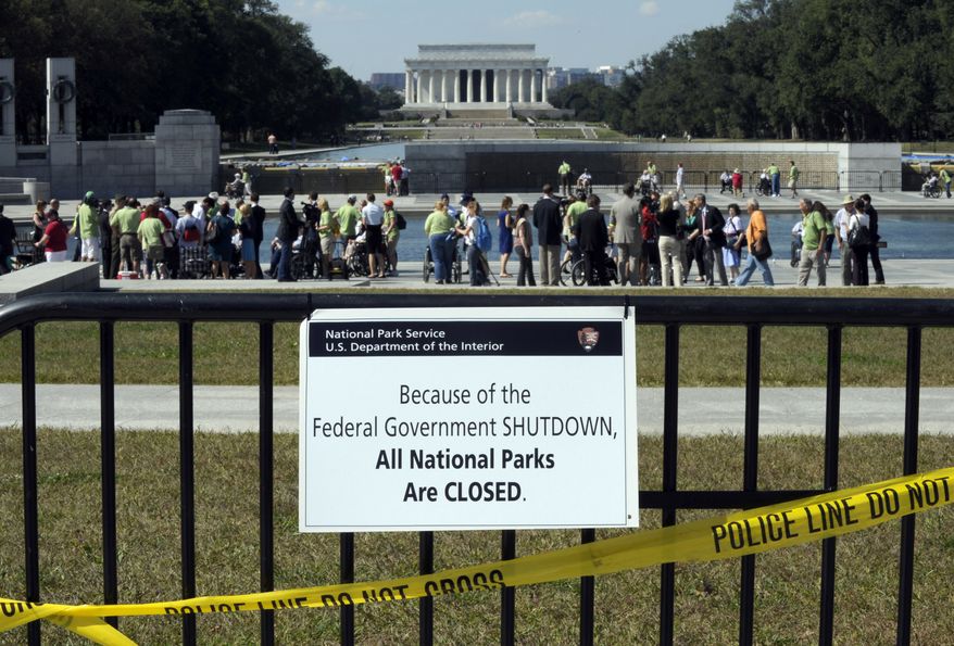 Despite signs stating that the national parks are closed, people visit the World War II Memorial in Washington, Wednesday, Oct. 2, 2013. Most of the visitors were WWII veterans who came to Washington on an honor flight to visit the memorial. It was an act of civil disobedience that marked the fact some barriers nor a government shutdown would keep a group of World War II veterans from visiting the monument erected in their honor. The Lincoln Memorial is in the background. (AP Photo/Susan Walsh)