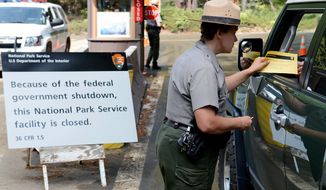 ** FILE ** Park Ranger Heidi Schlichting informs visitors of the closure of Yosemite National Park in California because of the government shutdown on Wednesday, Oct. 2, 2013. (AP Photo/The Fresno Bee, Craig Kohlruss) 