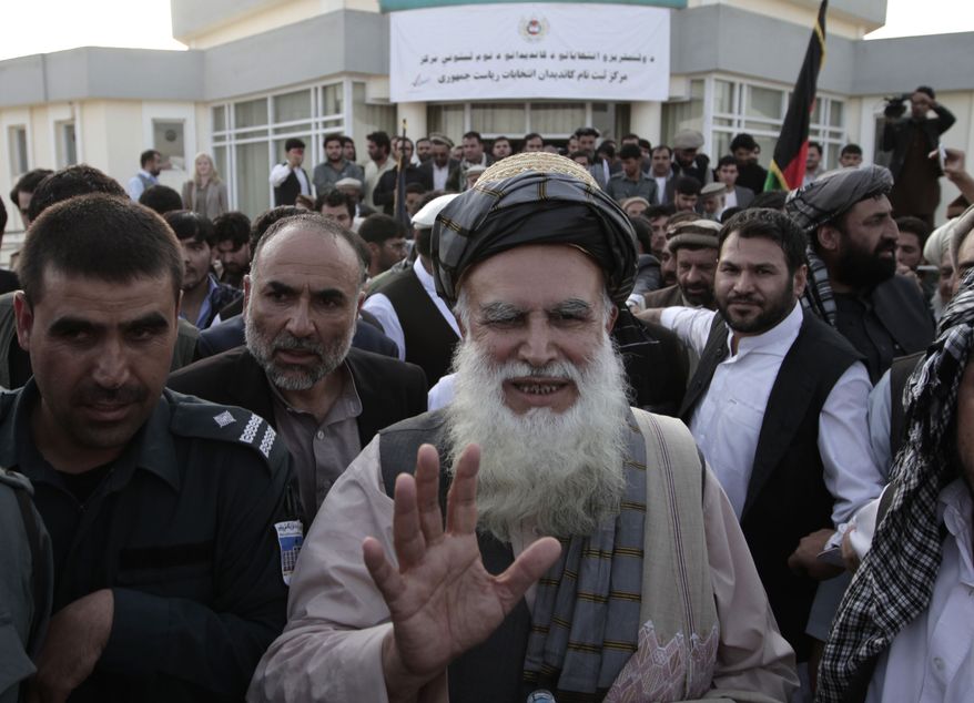 Abdul Rab Rasoul Sayyaf, an influential lawmaker and religious scholar, waves to his supporters after registering his candidacy in next year's presidential election in Kabul, Afghanistan, on Thursday, Oct. 3, 2013. Another former warlord, Ismail Khan, who formerly served as energy and water minister, said he will run for Mr. Sayyaf's first vice presidency in the April 5 vote. (AP Photo/Rahmat Gul)