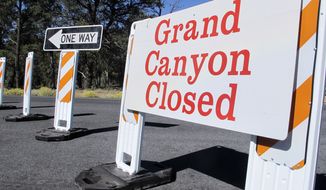 A sign at the south entrance to Grand Canyon National Park, Ariz., indicates the park is closed on Thursday, Oct. 3, 2013.  More than 400 national parks are closed as Congress remains deadlocked over federal government funding.  (AP Photo/Brian Skoloff)