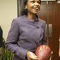 ** FILE ** Former Secretary of State Condoleezza Rice laughs after autographing a football following her visit with Cleveland Browns coaches and players at the team&#39;s training facility in Berea, Ohio, on Oct. 10, 2010. (AP Photo/Amy Sancetta)