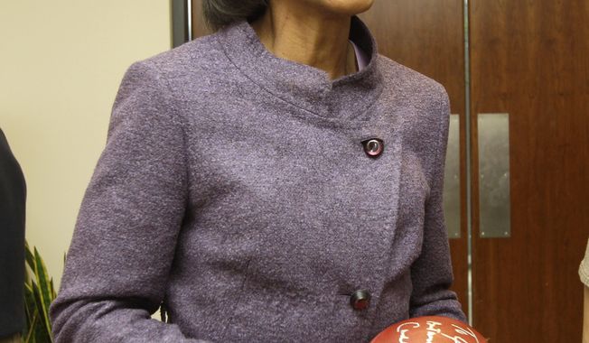 ** FILE ** Former Secretary of State Condoleezza Rice laughs after autographing a football following her visit with Cleveland Browns coaches and players at the team&#x27;s training facility in Berea, Ohio, on Oct. 10, 2010. (AP Photo/Amy Sancetta)