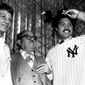 Mr. and Mrs. Martinez Jackson, left, look on as their son Reggie models his New York Yankee uniform for the press on Nov. 29, 1976 after the announcement that he signed a $3 million, five year contract with the Yanks.  (AP Photo)
