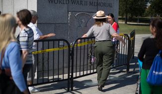 A National Park Service ranger stops a tourist from entering the World War II memorial during its closure due to the government shutdown in Washington, DC., Wednesday, October 2, 2013.  (Andrew S Geraci/The Washington Times)