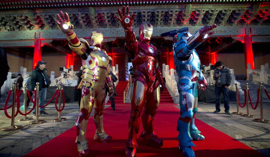 FILE - In this Saturday, April 6, 2013 file photo, Chinese performers dressed as Iron Man pose for photos during a promotional event for the movie &quot;Iron Man 3&quot; before its release in China in early May at the Imperial Ancestral Temple in Beijing&#39;s Forbidden City. Hong Kong Disneyland is adding an Iron Man-themed area in the hopes that the Marvel superhero&#39;s success at the Chinese box office will help draw more visitors to the underachieving resort. The park said Tuesday, Oct. 8 that the Iron Man Experience is planned to open by late 2016. (AP Photo/Andy Wong, File)
