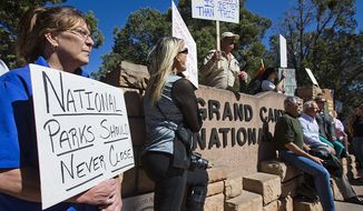 Tammy Cox (left), a worker at a Holiday Inn in Tusayan, Ariz., joins nearly 100 other protesters at the south entrance to the Grand Canyon. (Associated Press)