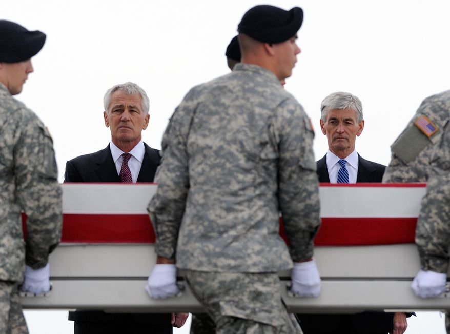 ** FILE ** Defense Secretary Chuck Hagel, left, and Army Secretary John McHugh, right, watch an Army carry team move a transfer case containing the remains of Pfc. Cody J. Patterson Wednesday, Oct. 9, 2013, at Dover Air Force Base, Del. According to the Department of Defense, Patterson, 24, of Philomath, Ore., died Oct. 6, 2013, in Zhari district, Afghanistan of injuries sustained when enemy forces attacked his unit with an improvised explosive device. (AP Photo/Steve Ruark)