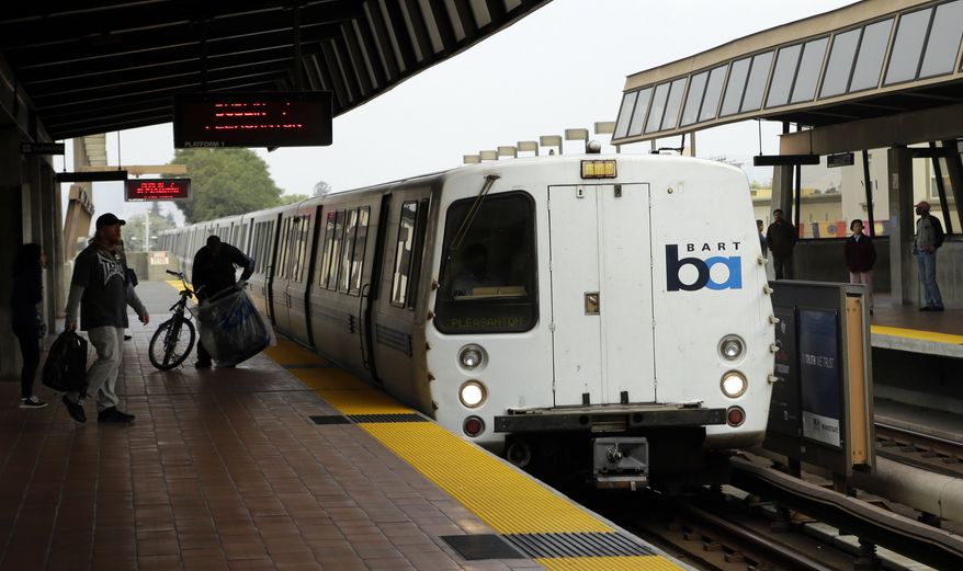 ** FILE ** Bay Area Rapid Transit travelers wait to board an arriving train Saturday, Oct. 12, 2013, in Oakland, Calif. (AP Photo/Ben Margot)