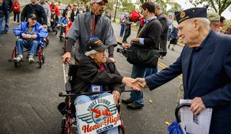 Mike Lauriente (right) of Howard County, Md., greets fellow World War II veteran Dale Nakken, who flew from Puget Sound, Wash., as they make their way to the World War II Memorial for the Million Vet March against the closure of the monument. Story, A12. (Andrew Harnik/The Washington Times)