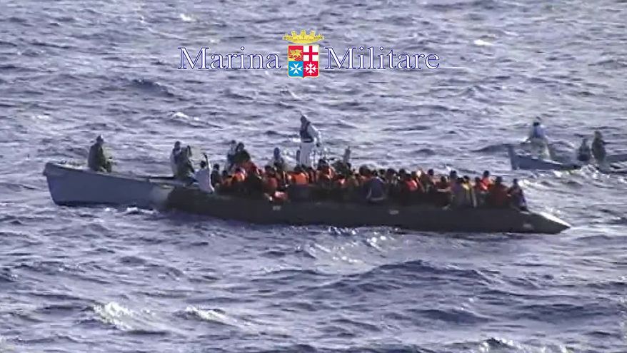 In this photo grabbed from a footage released by the Italian Navy Sunday, Oct. 13, 2013, migrants receive help from two raft from the Italian Navy ship Libra, off the Sicilian island of Lampedusa Saturday, Oct.12, 2013. In recent days hundreds of migrants have drowned as smugglers' ship packed with migrants sank or capsized. The deaths have sharpened calls for a coordinated European response to the wave of asylum-seeker fleeing war and repression making their way to Libya to embark on a sea journey, mostly in rickety smugglers' boats en route to Italy's southernmost island of Lampedusa, just 70 kilometers (50 miles) away. Despite the perils, the boats keep coming. Authorities have rescued hundreds more at sea this weekend. (AP Photo/Italian Navy HO)