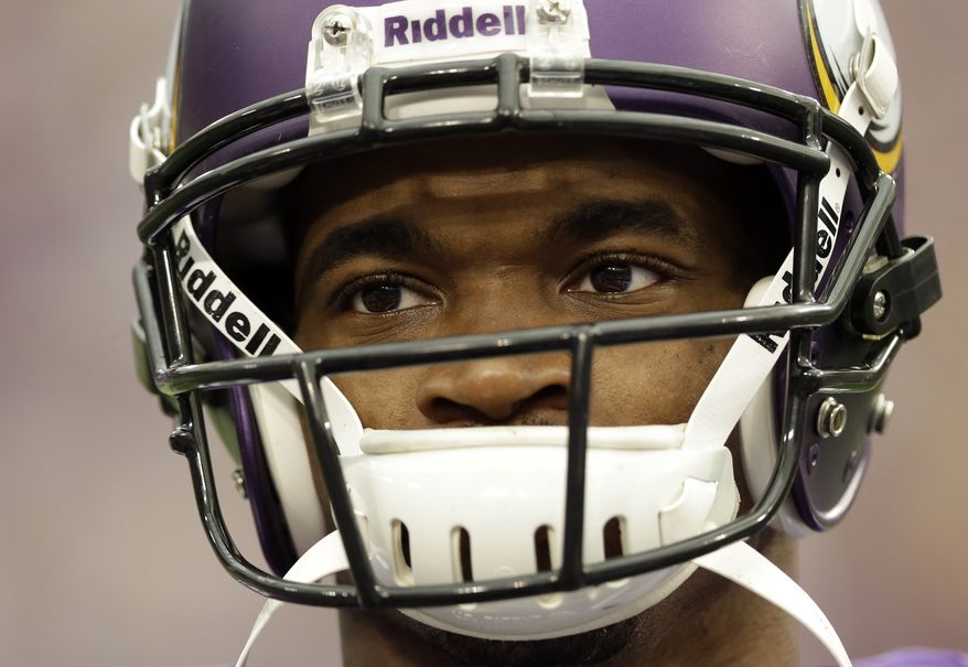 Minnesota Vikings running back Adrian Peterson pauses during introductions before an NFL football game against the Carolina Panthers in Minneapolis, Sunday, Oct. 13, 2013. One of the star running back's sons, a 2-year-old in South Dakota, died Friday after an alleged attack in a child abuse case. (AP Photo/Michael Conroy)
