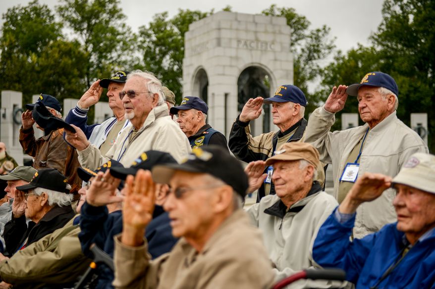 World War II veterans, traveling with an honor flight from Puget Sound, Wash. salute as they are welcomed to the World War II Memorial after protesters removed barricades for the government shutdown, Washington, D.C., Sunday, October 13, 2013. (Andrew Harnik/The Washington Times)