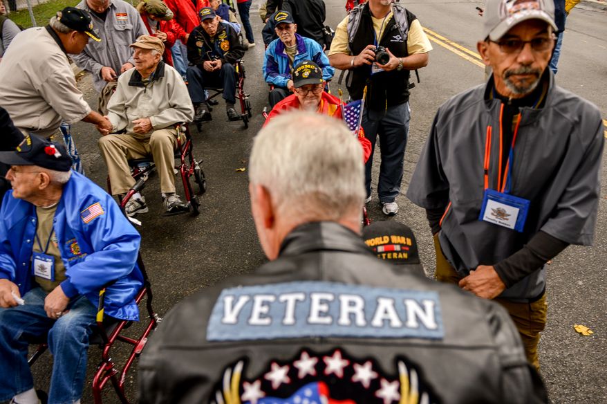 Air Force Reservist Jeff Harris of Montgomery, Ala., center, greets retired World War II veterans traveling with an honor flight as they make their way to the World War II Memorial after protesters removed barricades for the government shutdown, Washington, D.C., Sunday, October 13, 2013. (Andrew Harnik/The Washington Times)