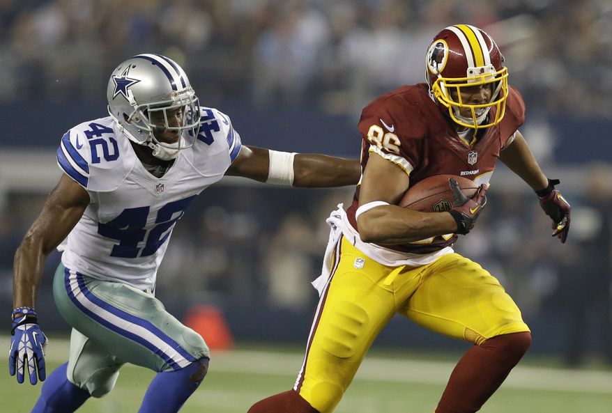 Dallas Cowboys free safety Barry Church (42) attempts to reach Washington Redskins tight end Jordan Reed (86) in the first half of an NFL football game, Sunday, Oct. 13, 2013, in Arlington, Texas. (AP Photo/LM Otero)