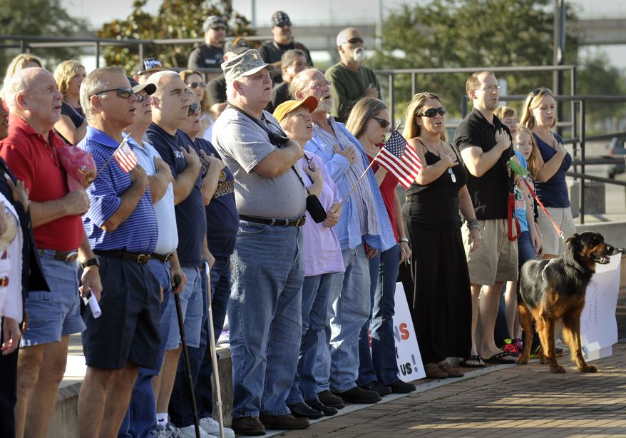 Veterans and supporters sing the National Anthem at a rally to back veterans Sunday Oct. 13, 2013 at the Veterans Memorial Wall in Jacksonville, Florida. The rally was held at the same time as other rallies nationwide and the Million Vet March on the Memorials in Washington, D. C. to protest the closing of memorials that are normally open at all times and have no staff to guard them under normal circumstances. (AP Photo/The Florida Times-Union, Will Dickey)