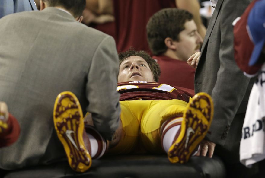 Washington Redskins Nick Sundberg (57) is worked by team staff during the second half of an NFL football game against the Dallas Cowboys Sunday, Oct. 13, 2013, in Arlington, Texas. (AP Photo/LM Otero)