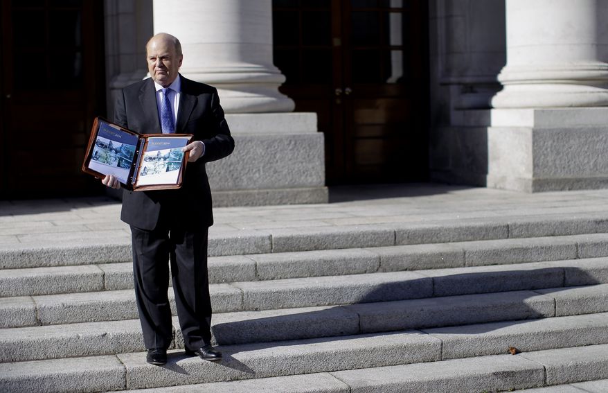 Minister for Finance Michael Noonan poses with the Budget 2014 on the steps of government building's, Dublin, Ireland, Tuesday, Oct. 15, 2013. Irish finance minister Michael Noonan is expected to unveil another tough budget Tuesday. Noonan and the Public Expenditure Minister, Brendan Howlin, will take a further 2.5bn euros (£2.1bn) out of the Republic of Ireland's economy. It is the last budget before the country leaves its EU-IMF bailout programme on 15 December. (AP Photo/Peter Morrison)