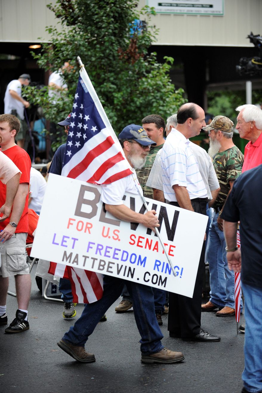 Tom Barbour of New Haven, Ky., carries a sign in support of Matt Bevin during the Fancy Farm picnic in Kentucky in August. Mr. Bevin, a businessman, praised Sen. Ted Cruz, Texas Republican, as the new face of the conservative movement and blasted Senate Minority Leader Mitch McConnell, who wrote the final debt deal with his Democratic counterpart Majority Leader Harry Reid. (Associated Press)