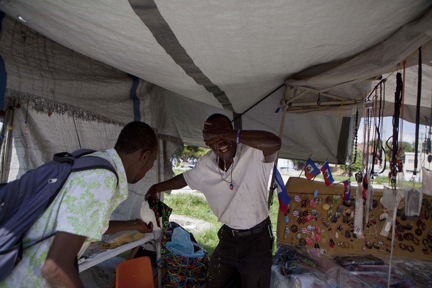 ** FILE ** A street vendor splashes water on his face to ease the discomfort from the tear gas fired by police during protests against President Michel Martelly's government, mainly about the higher cost of living in downtown of Port-au-Prince, Haiti, Thursday, Oct. 17, 2013. The protest happened on a national holiday known as Jean-Jacques Dessalines day, honoring one of the nation's founding fathers. (AP Photo/Dieu Nalio Chery)