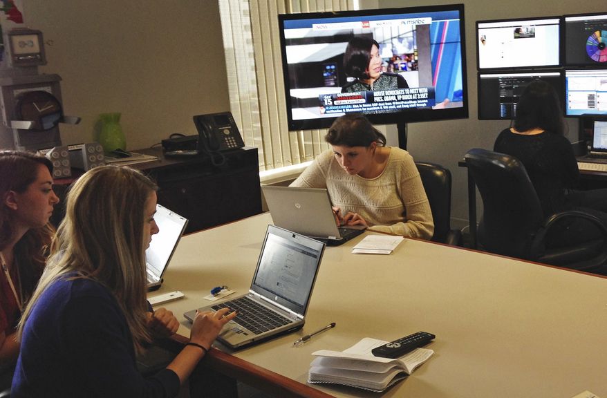 In this Oct. 15, 2013 photo, social media experts at the marketing agency FleishmanHillard work in a Chicago command center on the Get Covered Illinois marketing campaign. As the state-contracted agency pivots away from a full-force marketing barrage because of early technical problems with the health care law’s federal website, the social media team has assumed responsibility for educating Illinois consumers and tending to their frustrations. (AP Photo/Carla K. Johnson)