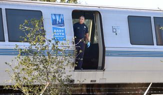 A Bay Area Rapid Transit police officer looks out from a car of a train that struck and killed two workers along Jones Road in Walnut Creek, Calif., on Saturday, Oct. 19, 2013. (AP Photo/The Mercury News, Dan Rosenstrauch)