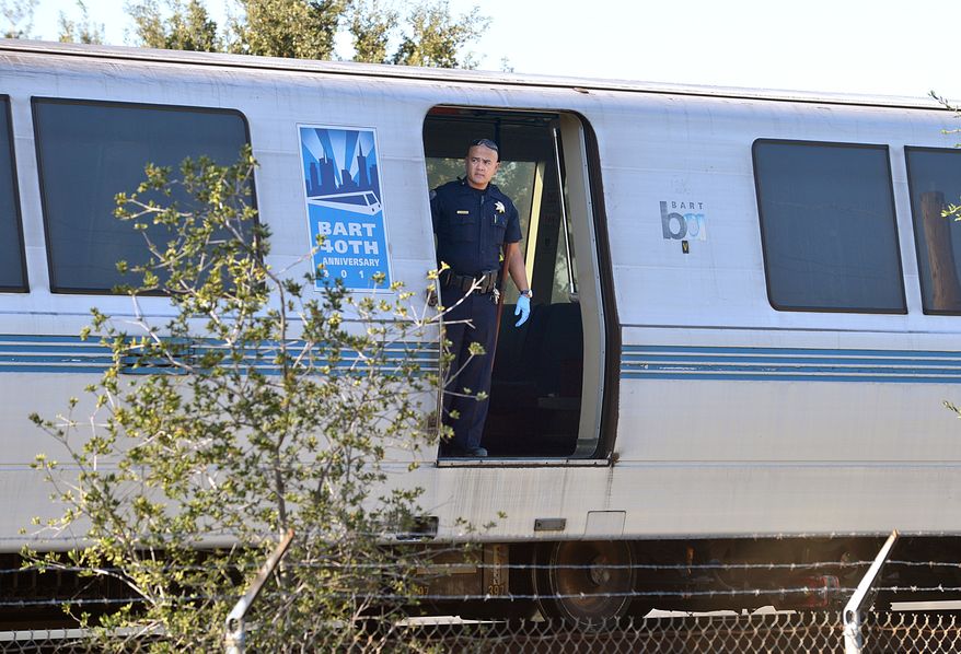A Bay Area Rapid Transit police officer looks out from a car of a train that struck and killed two workers along Jones Road in Walnut Creek, Calif., on Saturday, Oct. 19, 2013. (AP Photo/The Mercury News, Dan Rosenstrauch)