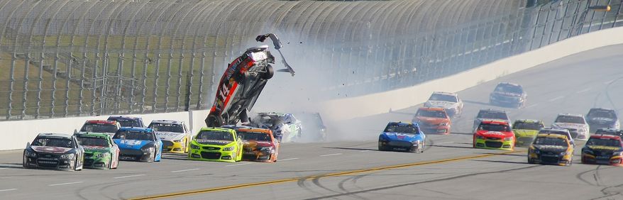 Sprint Cup Series driver Austin Dillon (14) goes airborne on the backstretch as Sprint Cup Series driver Jamie McMurray (1) leads cars on the final lap of the NASCAR Sprint Cup Series auto race at the Talladega Superspeedway in Talladega, Ala., Sunday, Oct. 20, 2013. McMurray won the race. (AP Photo/Greg McWilliams)