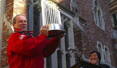 Larry Lucchino, president and CEO of the Boston Red Sox holds the World Series trophy during a Red Sox rally at the Yale Law School Nov. 17, 2004 in New Haven, Conn.  Lucchino, a 1971 graduate of Yale, was accompanied by the Yale Law School Dean Harold Hongyu Koh, right.  (AP Photo/Michelle McLoughlin)
