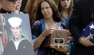 Elizabeth Strange, center, carries her son&#x27;s remains, with Breanna Hostetler, fiance of the deceased, right, as they depart after a a flag presentation ceremony for U.S. Navy Petty Officer 1st Class Michael Joseph Strange, a cryptology technician, in Logan Circle Thursday, Aug. 18, 2011, in Philadelphia. Strange was assigned to the Navy SEAL team whose Chinook helicopter was shot down Aug. 6 by a rocket-propelled grenade in what has become the deadliest single loss for U.S. forces in the decade-long war in Afghanistan. (AP Photo/Alex Brandon)