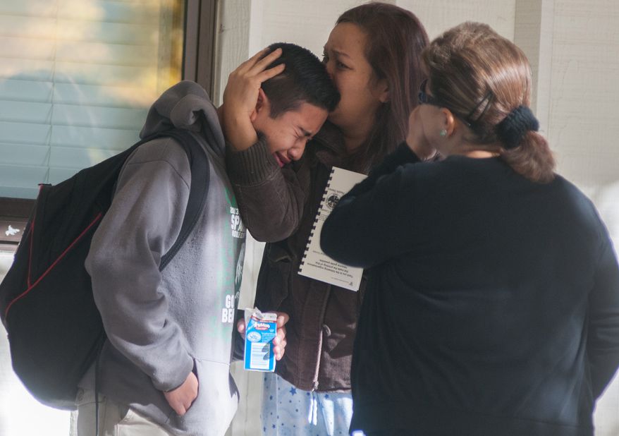 A Sparks Middle School student cries after being released from Agnes Risley Elementary School, to which some students were evacuated, after a shooting at the middle school in Sparks, Nev., on Monday, Oct. 21, 2013. A middle school student opened fire on campus just before the starting bell, wounding two boys and killing a staff member who was trying to protect other children, Sparks police said. The lone suspected gunman was also dead, though it's unclear whether the student committed suicide. (AP Photo/Kevin Clifford)