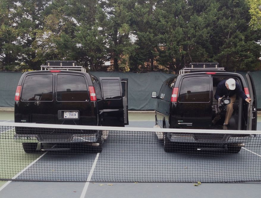 Press vans from the motorcade of President Obama park on the tennis courts of the Sidwell Friends School in Washington on Oct. 22, 2013. President Obama and first lady Michelle Obama are attending parent teacher meetings at the school where their daughters Sasha and Malia attend. (Associated Press) **FILE**