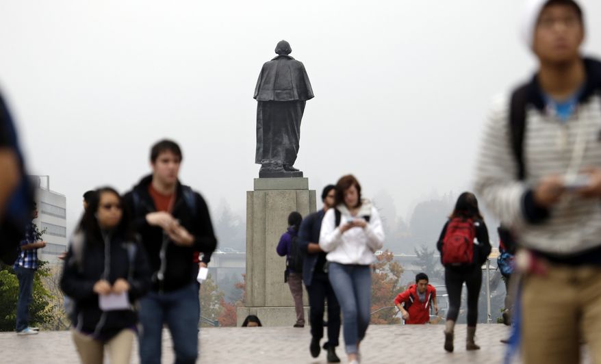 In this file photo, University of Washington students walk past a statue of George Washington that towers near an entrance to the campus in Seattle on Tuesday, Oct. 15, 2013. (AP Photo/Elaine Thompson) **FILE**