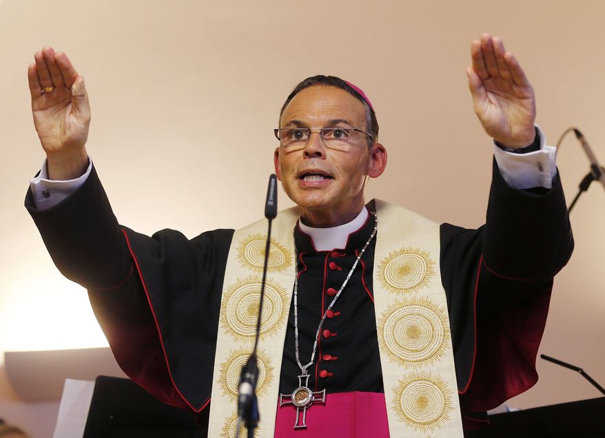 Bishop Franz-Peter Tebartz-van Elst blesses a new kindergarten in Frankfurt, Germany, on Thursday, Aug. 29, 2013. Pope Francis has expelled the bishop from his diocese temporarily because of a scandal over a 31 million euro ($42.64 million) project to build a new residence complex in the Diocese of Limburg. (AP Photo/Michael Probst)