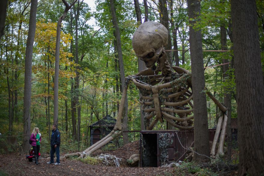 Allen and Jill Bennett, owners of the Creepy Woods Haunted Woods and Bennett's Curse Haunted Houses, stand under a 35 foot tall animatronic skeleton that they just installed this year, in Kingsville, MD., Wednesday, October 16, 2013. (Andrew S Geraci/The Washington Times)