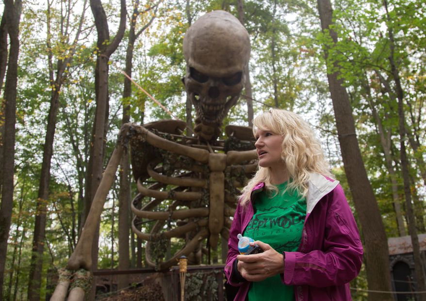 Jill Bennett, owner of the Creepy Woods Haunted Woods and Bennett's Curse Haunted Houses, stands under a 35 foot tall animatronic skeleton that they just installed this year, in Kingsville, MD., Wednesday, October 16, 2013. (Andrew S Geraci/The Washington Times)