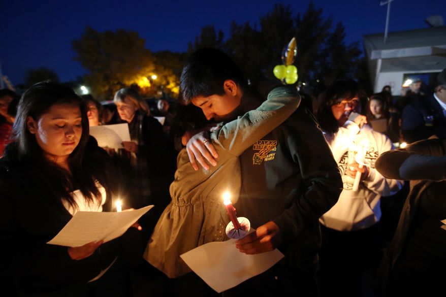Hundreds of students and residents attend a candlelight vigil at Sparks Middle School in Sparks, Nev., on Wednesday, Oct. 23, 2013, in honor of slain teacher Michael Landsberry and two 12-year-old students who were injured after a fellow student open fire at the school on Monday, before turning the gun on himself. (AP Photo/Cathleen Allison)