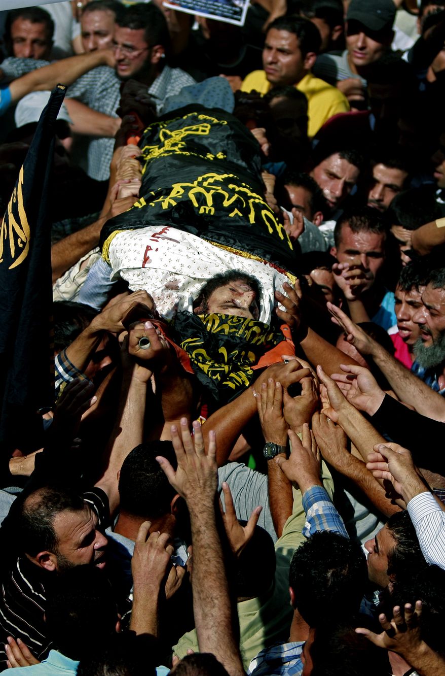 Palestinians carry the body of Islamic Jihad militant, Mohamed Aatzi wrapped in an Islamist flag during his funeral, in the village of Beit Laqiya near the West Bank city of Ramallah, Wednesday, Oct. 23, 2013. Israel’s security service and the military say Israeli forces have killed Aatzi in the West Bank believed to be responsible for a Tel Aviv bus bombing last year. The green flags represent the ruling Hamas militant group. (AP Photo/Majdi Mohammed)