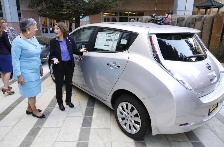 Mary Nichols, chairwoman of the California Air Resources Board, left, and Deb Markowitz, secretary of  the Vermont Agency of  Natural Resources, view an electric car displayed in Sacramento, Calif., following a news conference to announce the signing of an agreement on zero-emissions cars, Thursday, Oct. 24, 2013. (AP Photo/Rich Pedroncelli)