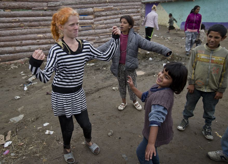 Minka Ruseva, daughter of Sasha Ruseva, left, dances along with other children in a Roma neighborhood of Nikolaevo, Bulgaria, Friday, Oct. 25, 2013. Sasha Ruseva, a Bulgarian Roma woman from this town, is under investigation by Bulgarian authorities trying to find out if she is the mother of a suspected abduction victim in neighboring Greece known as "Maria" whose case has triggered a global search for her real parents. (AP Photo/Vadim Ghirda)