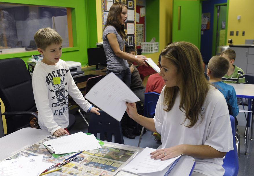 In this photo taken Oct. 9, 2013, Josh Gillespie, 8, left, talks about a math problem with a parent volunteer Shannon Morgan, right, during a math lesson with teacher Jennifer Whittaker, center, at a homeschooling co-operative at Andrews Air Force Base, Md. A growing number of military parents have embraced home schooling, seeking to put an end to the age-old tradition for military kids of switching schools. (AP Photo/Susan Walsh)