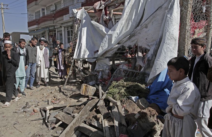 Afghans look at wreckage after a roadside bomb exploded on the outskirts of Kabul, Afghanistan, on Sunday, Oct. 27, 2013. An Afghan official and witnesses said the bomb, apparently targeting a group of soldiers, killed a civilian in a market in the capital as the soldiers and officers waited for a vehicle to take them to their workplace. (AP Photo/Rahmat Gul)