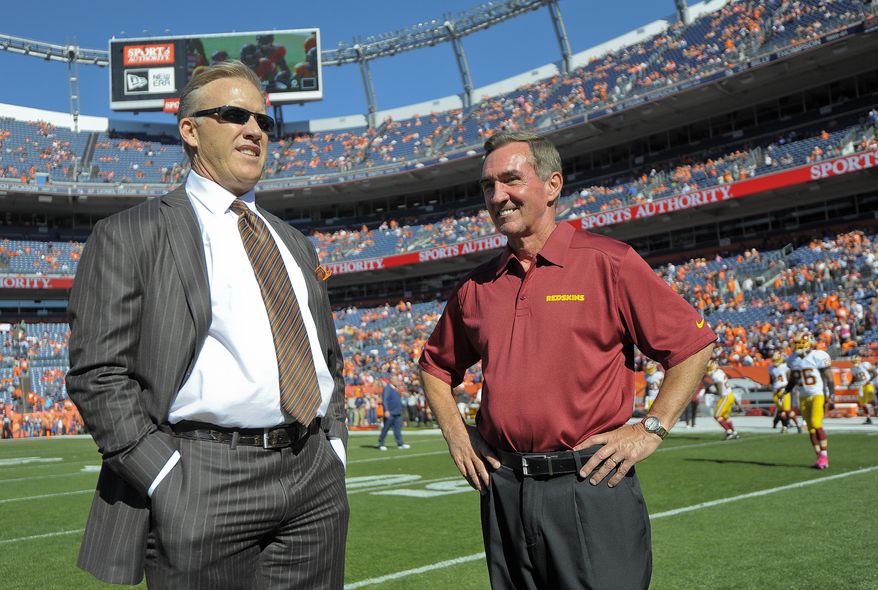 Denver Broncos executive vice president of football operations John Elway, left, talks with Washington Redskins coach Mike Shanahan before an NFL football game, Sunday, Oct. 27, 2013, in Denver. (AP Photo/Jack Dempsey)