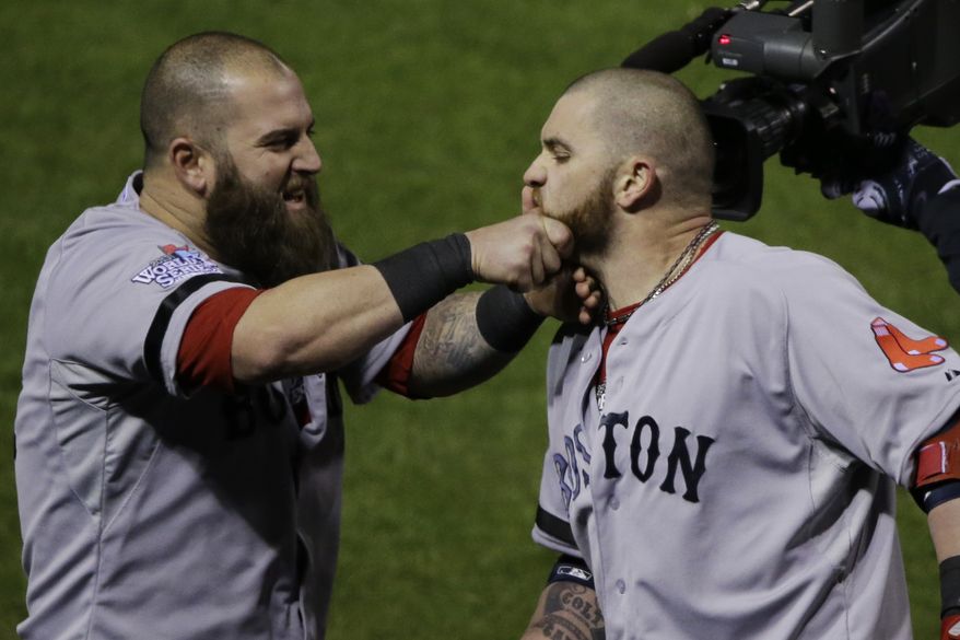 The Boston Red Sox's Mike Napoli (left) pulls teammate Jonny Gomes' beard after Gomes hit a three-run home run off St. Louis Cardinals relief pitcher Seth Maness during the sixth inning of Game 4 of baseball's World Series on Sunday, Oct. 27, 2013, in St. Louis. (AP Photo/Charlie Neibergall)