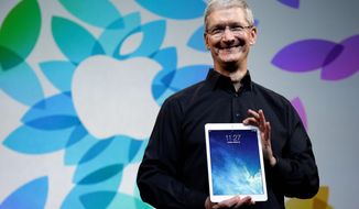 ** FILE ** In this Oct. 28, 2013, file photo, Apple CEO Tim Cook, holding the new iPad Air, said he remains confident the company can provide the products consumers want. (ASSOCIATED PRESS)