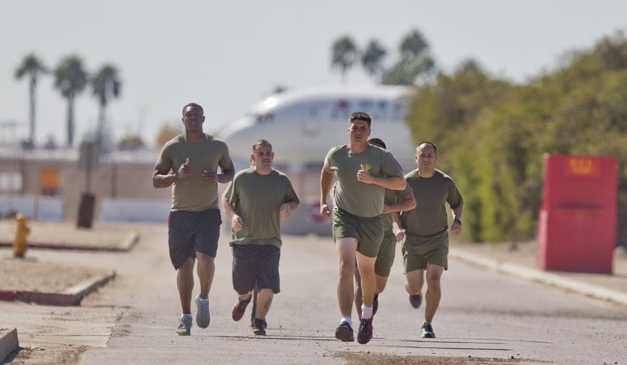 In a Thursday, Oct. 17, 2013 photo, a group of sailors and Marines who failed the so-called "tape test'' are led by an instructor on a three mile run as they work to improve their fitness and remain in the military, at the Marine Corps Recruit Depot in San Diego. Doctors say a number of military personnel are turning to liposuction to remove excess fat from around the waist so they can pass the Pentagon's body fat test. Some service members say they have no other choice because the Defense Department's method of estimating body fat is weeding out not just flabby physiques but bulkier, muscular builds. A number of fitness experts and doctors agree, and they're calling for the military's fitness standards to be revamped. (AP Photo/Lenny Ignelzi)