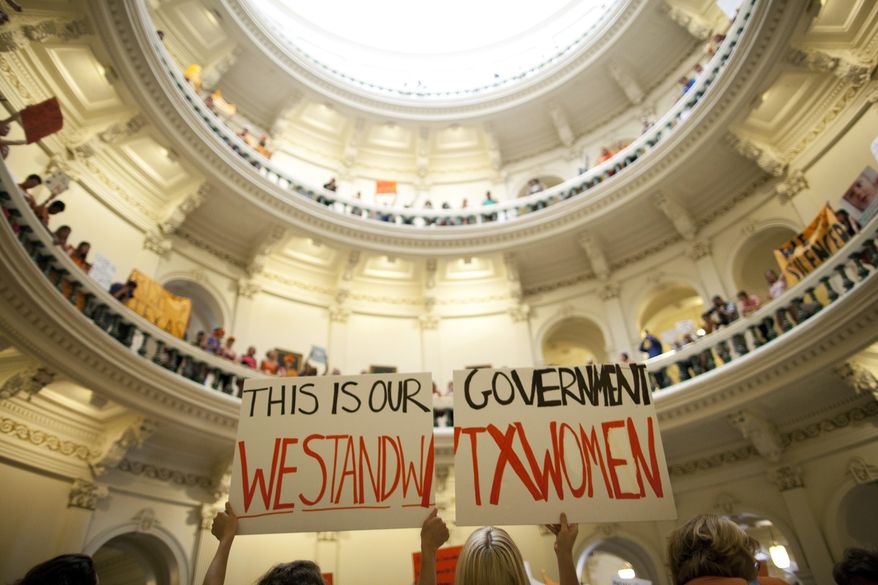 FILE - In this July 12, 2013 file photo, abortion rights supporters rally on the floor of the State Capitol rotunda in Austin, Texas. New abortion restrictions passed by the Texas Legislature are unconstitutional and will not take effect as scheduled on Tuesday, Oct. 29, 2013, a federal judge has ruled. (AP Photo/Tamir Kalifa, File)