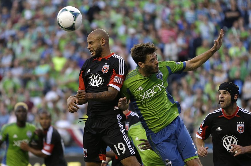 D.C. United's Kyle Porter, left, and Seattle Sounders's Brad Evans, right, head the ball in the second half of an MLS soccer match, Wednesday, July 3, 2013, in Seattle. The Sounders beat D.C. United, 2-0. (AP Photo/Ted S. Warren)
