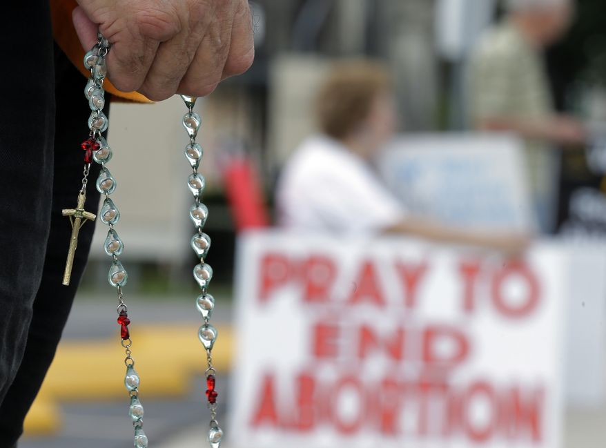 Phil Thiltrickett, an opponent of an abortion, holds a rosary as he prays outside a Planned Parenthood Clinic, Tuesday, Oct. 29, 2013, in San Antonio. (AP Photo/Eric Gay)