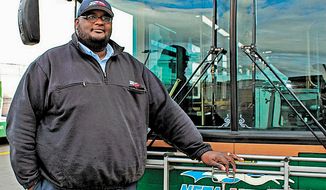 Darnell Barton, a driver for the Niagara Frontier Transportation Authority, poses in front of a bus in Buffalo, N.Y., on Monday, Oct. 28, 2013. On Oct. 18, Mr. Barton&#x27;s decisive action stopped a woman from leaping from a roadway bridge to her death on a highway below. Caught between the rules of his job and his training as a first responder, Mr. Barton stopped his bus, grabbed the woman and brought her back over the rail to safety. (AP Photo/Niagara Frontier Transportation Authority, Doug Hartmayer)
